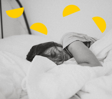 Woman lies sleeping in bed. Illustrated yellow semi-circles form an arching pattern at the top of the image.